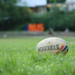 white and red soccer ball on green grass field during daytime